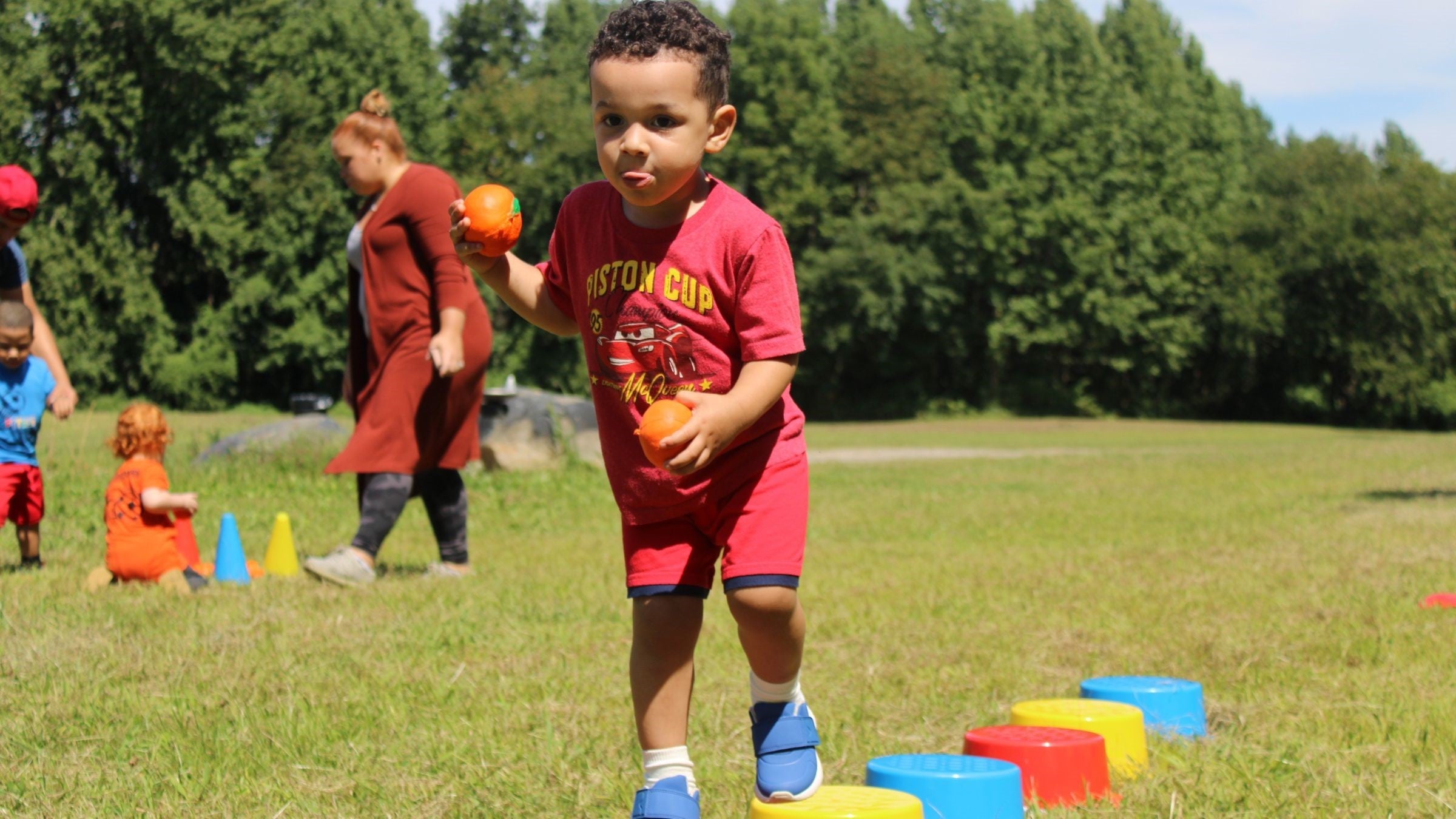 Children sitting on soccer balls in a row during a Fit Soccer Kids birthday activity