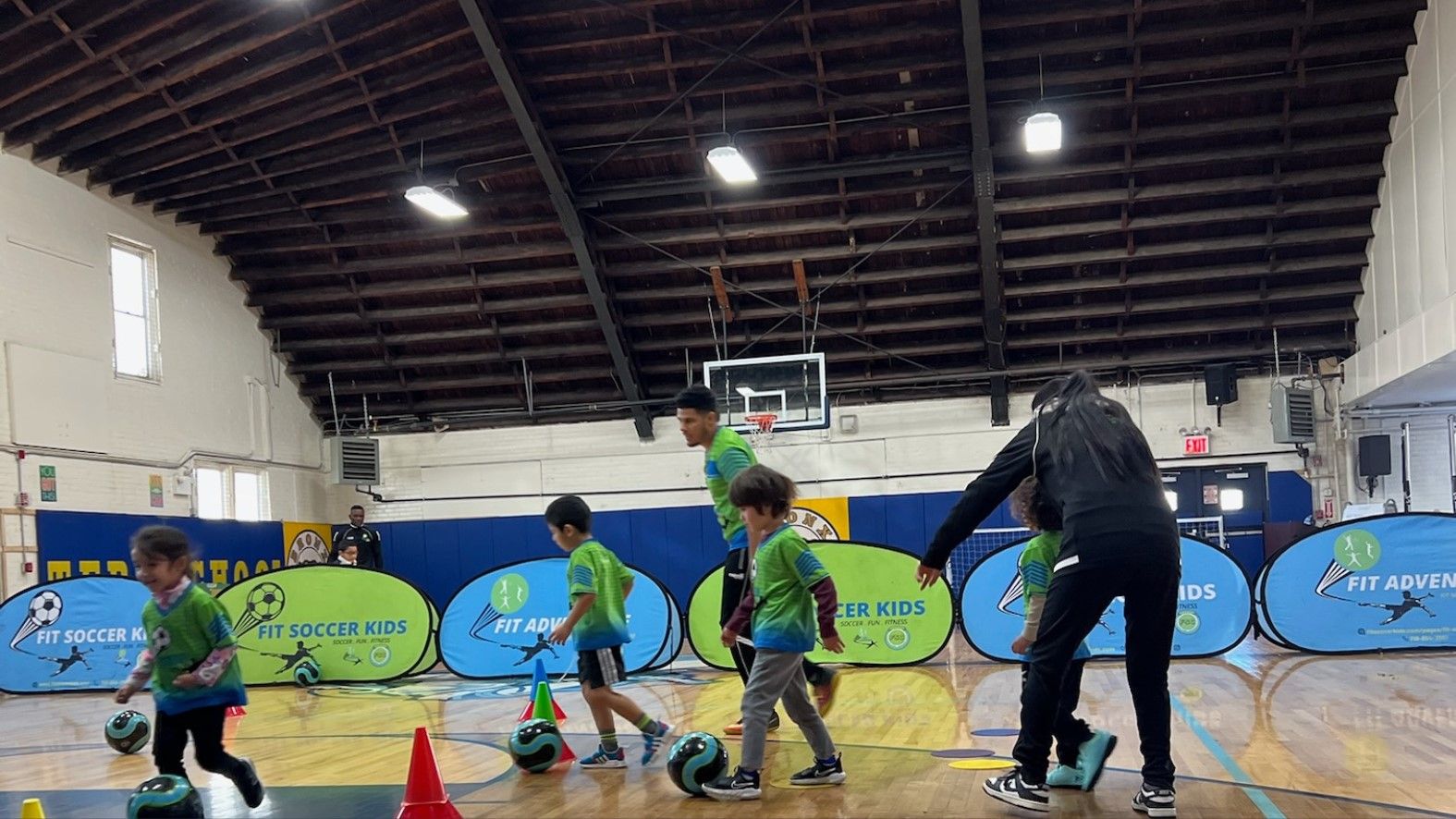 Children and coaches during an indoor Fit Soccer Kids school program session