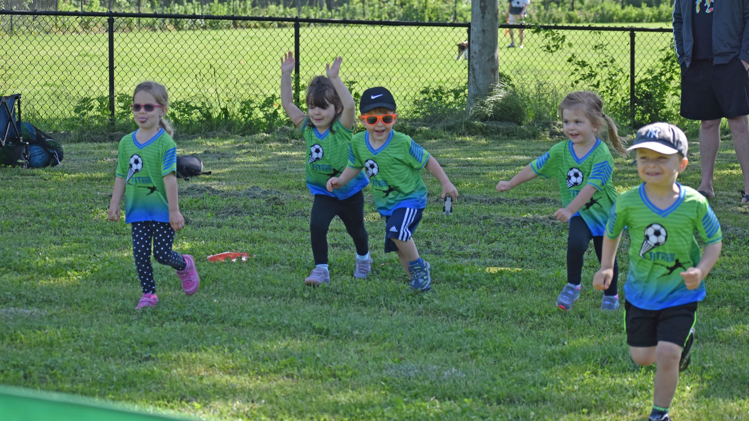 Children celebrating during an outdoor Fit Soccer Kids program session